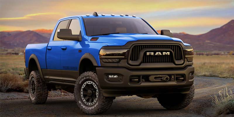 A blue RAM 2500 sitting majestically at sunset backed by picturesque mountains.
