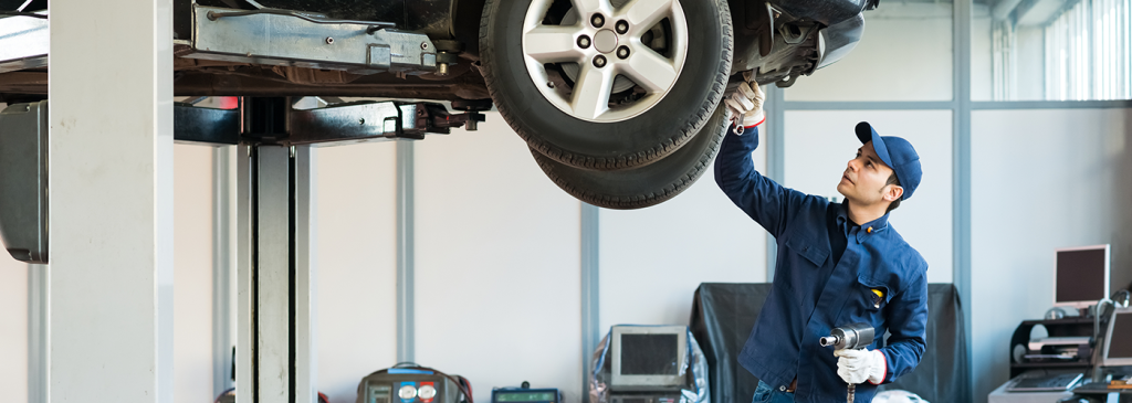 A technician performing routine 30,000-mile maintenance on a vehicle.