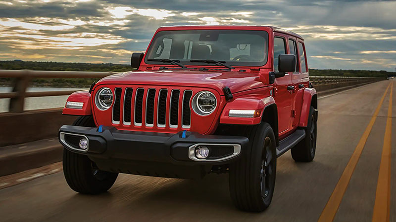 A red 2023 Jeep Wrangler driving down the highway