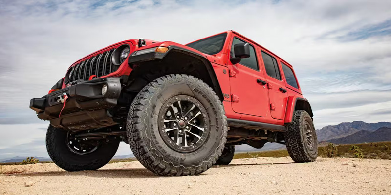 A 2025 Jeep Wrangler sitting on a desert landscape shot from below